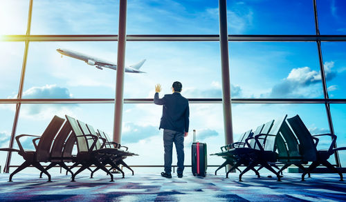 Rear view of man standing on chair