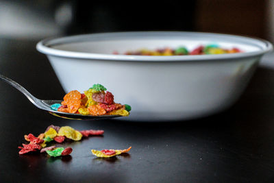 Close-up of cereals in bowl and spoon on table