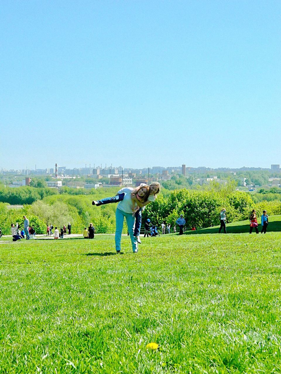 grass, plant, sky, green color, real people, nature, field, copy space, land, clear sky, men, day, group of people, lifestyles, environment, large group of people, landscape, crowd, leisure activity, outdoors