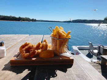 Breakfast on table by sea against sky