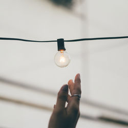 Close-up of hand holding light bulb