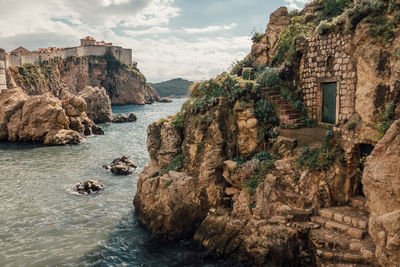 Scenic view of sea by cliff against sky