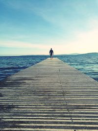 Rear view of man on jetty against sea