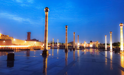 Illuminated wooden posts in water at night