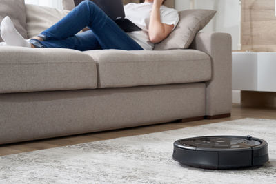 Midsection of woman sitting on sofa at home