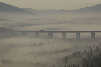 Scenic view of bridge over mountains against sky