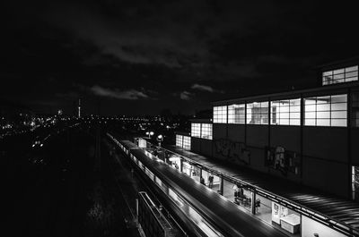 Blur image of illuminated at railroad station against sky at night