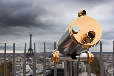 Close-up of coin-operated binoculars against cityscape