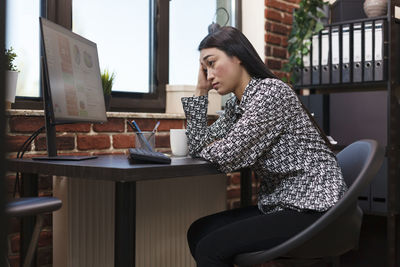 Young woman using laptop while sitting at cafe