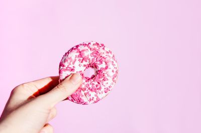 Midsection of pink holding ice cream against gray background