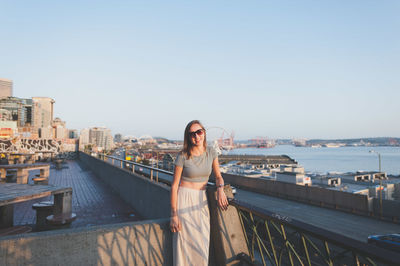 Woman standing by sea against clear sky