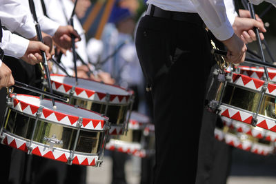 Midsection of drummers performing outdoors