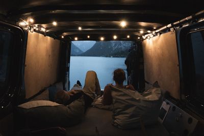 Rear view of people sitting in illuminated room