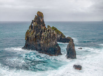 Rock formation in sea against sky