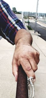 Close-up of man holding hands on street