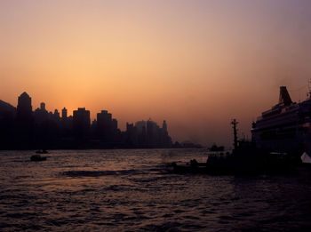 Silhouette of boats sailing in sea at sunset