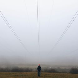 Man standing on field in foggy weather
