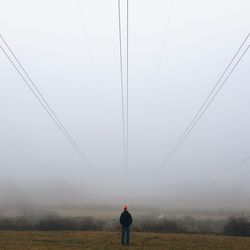 People standing on field in foggy weather