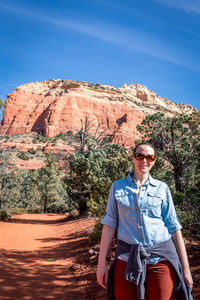 Portrait of woman standing against rock formation