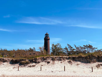 Lighthouse by sea against sky