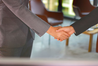 Midsection of business colleagues shaking hands