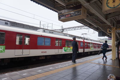 People by train at railroad station platform