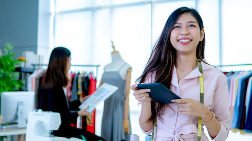 Smiling young woman using smart phone at store