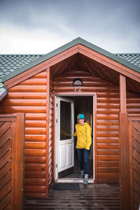 Woman in yellow walking through front door at a house in iceland