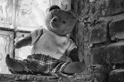 Boy sitting on wall with toy