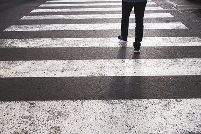 Low section of woman walking on road