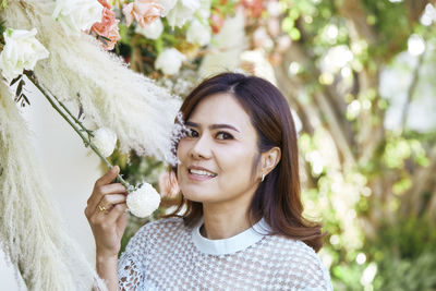 Portrait of smiling woman touching decorations