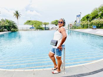 Portrait of young woman standing in swimming pool