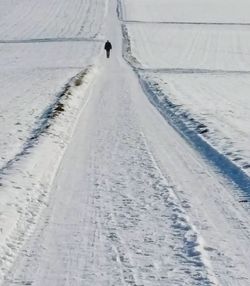 Tire tracks on snow covered road during winter