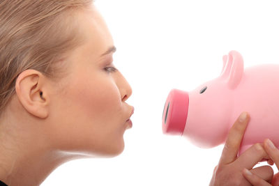 Close-up portrait of a beautiful woman drinking water against white background