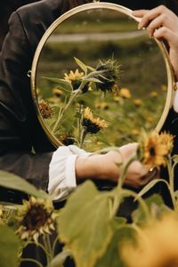 Midsection of woman holding a mirror 