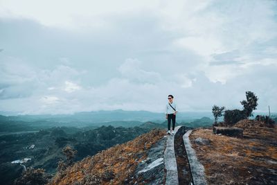 Man standing on mountain against sky