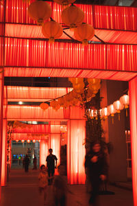 People walking in illuminated building at night