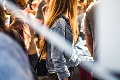 Midsection of woman amidst crowd on street