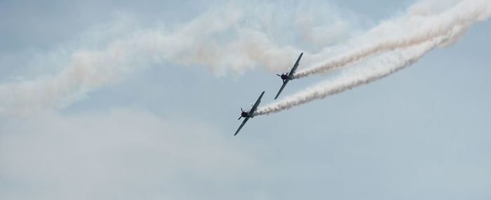 Low angle view of airshow against sky