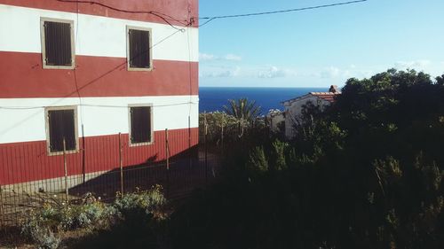 Scenic view of sea by buildings against sky