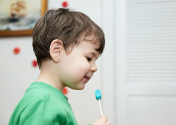 Cute baby boy enjoying a lollipop at home