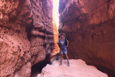 Woman standing on cliff amidst rocky mountains at bryce canyon