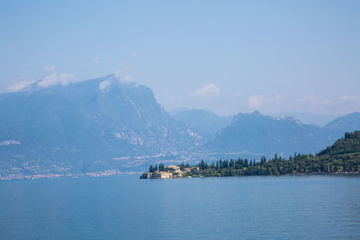 Scenic view of sea by mountains against sky