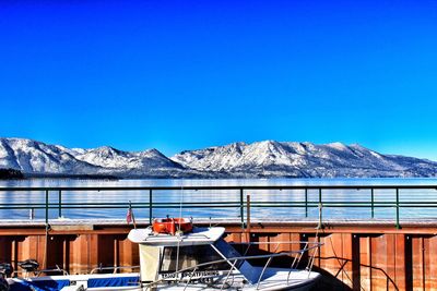 Scenic view of snow covered mountains against clear blue sky