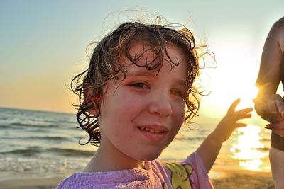 Portrait of smiling boy on beach against sky