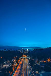 Light trails in city against clear sky at night