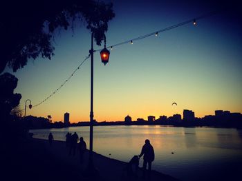 Silhouette of people in water at sunset