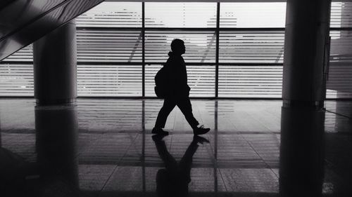 Full length of woman walking on tiled floor