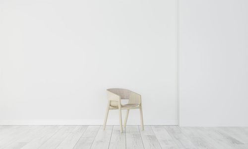 Empty chair against white wall