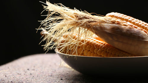 Close-up of bread on table against black background